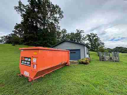 Big Orange 23-yard roll-off dumpster in a service yard